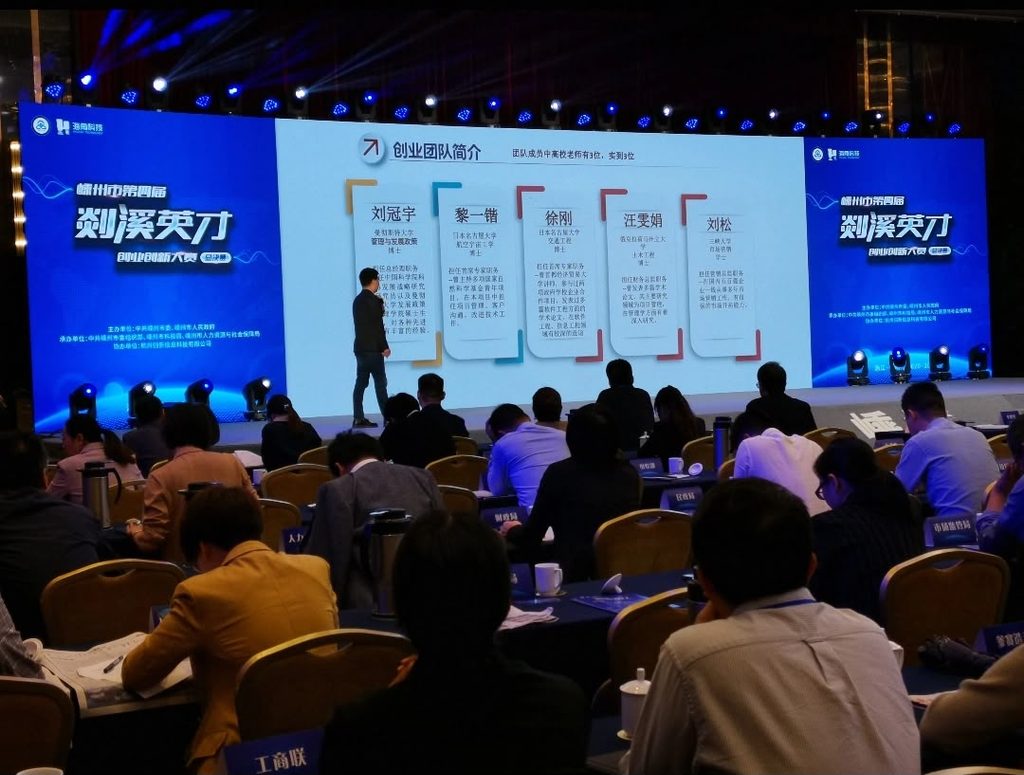 Project pitching, presenting cross‑disciplinary R&D team on competition stage